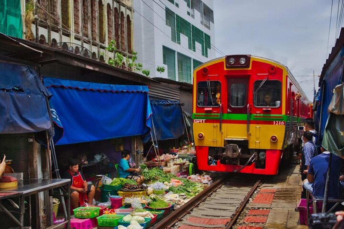 kereta api merah dan kuning di landasan bersebelahan pasar