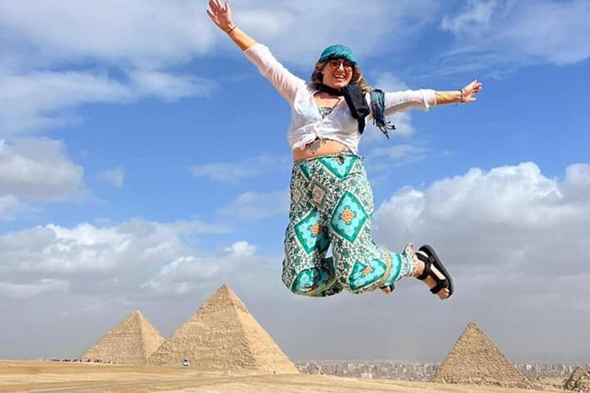 isang babaeng tumatalon sa hangin sa harap ng mga piramide