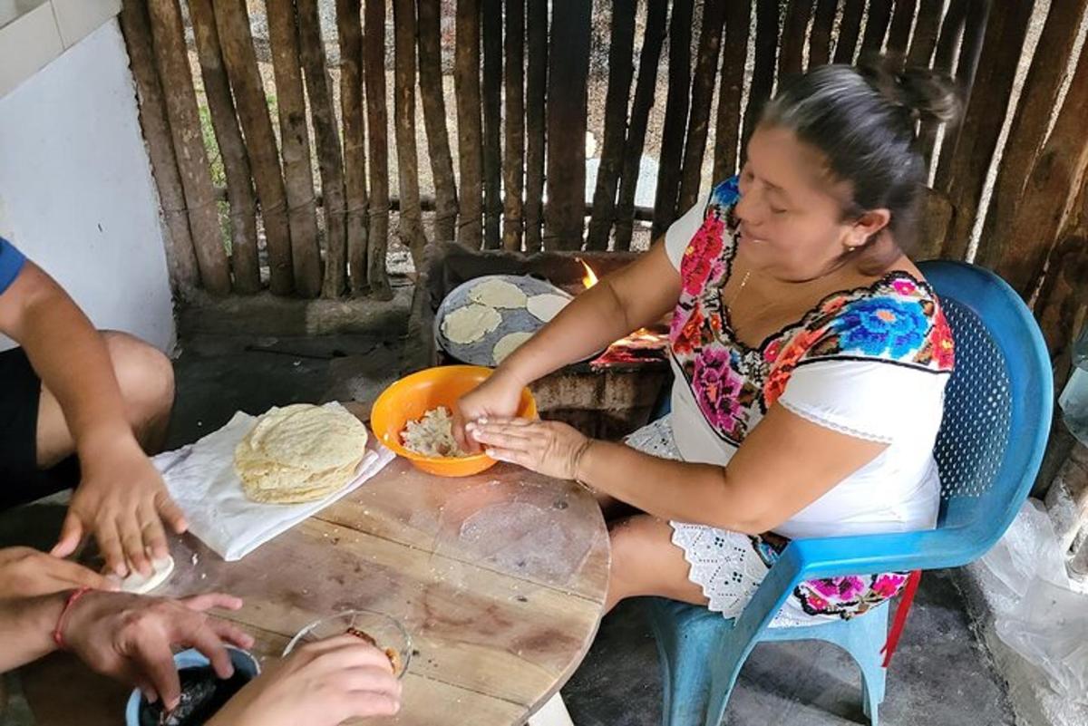 seorang wanita duduk di meja dengan sepinggan makanan