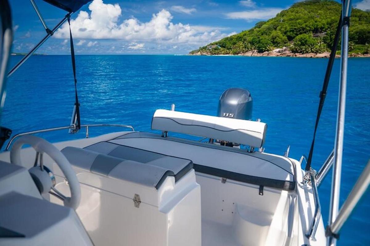 Un barco blanco en el agua con una isla al fondo.