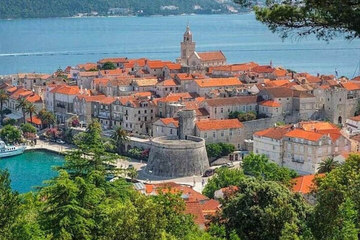 mesto s oranžovými strechami a vodnou plochou
