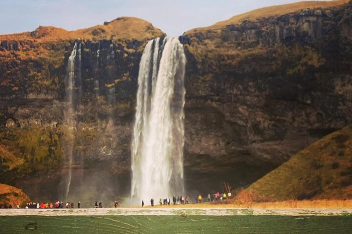 sekumpulan orang berdiri di hadapan air terjun