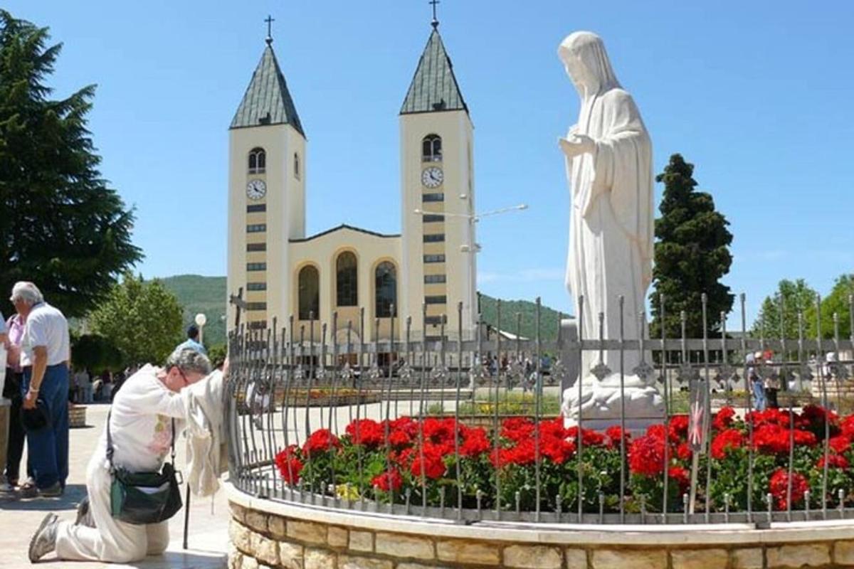Un hombre plantando flores frente a una iglesia.