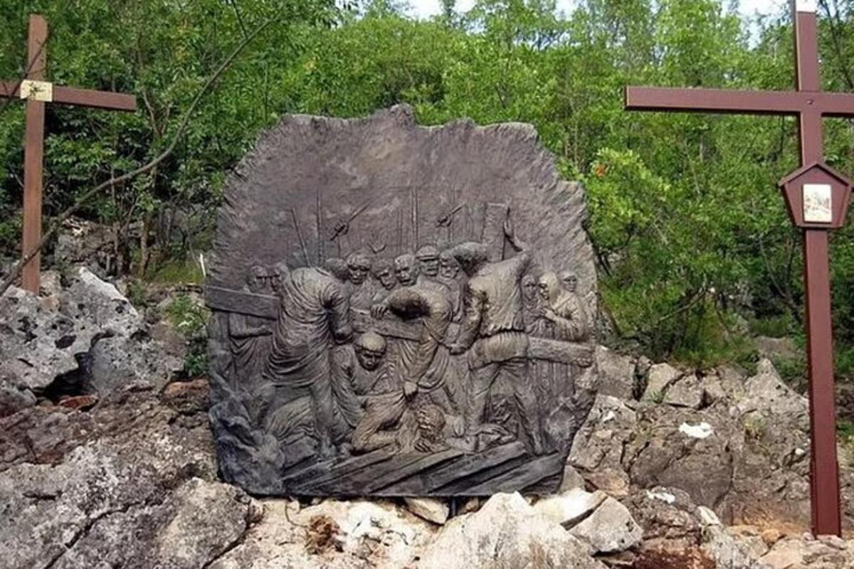 Una estatua de piedra de un grupo de personas sobre una roca.