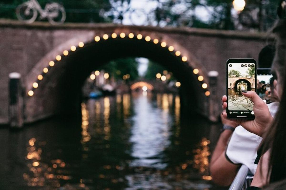 žmogus, fotografuojantis tiltą mobiliuoju telefonu