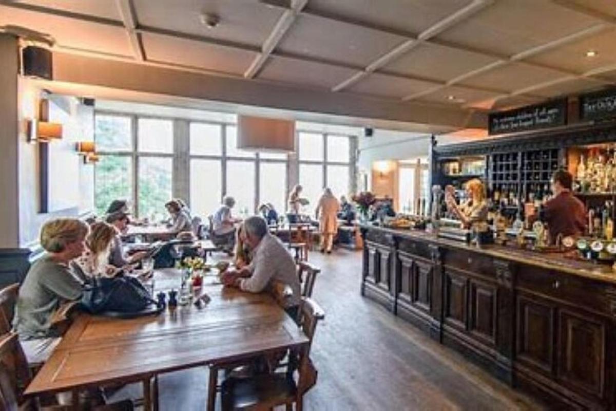 sekumpulan orang yang duduk di sebuah bar di sebuah restoran