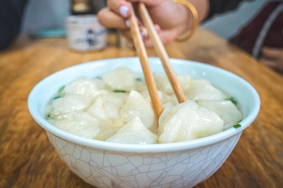 拿着筷子在碗里吃饭的人
