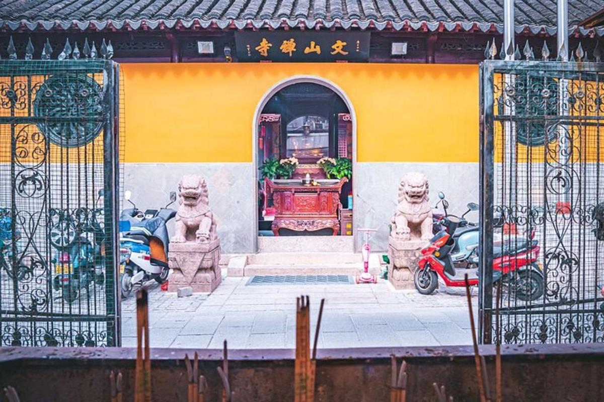 a building with two motorcycles parked in front of a gate