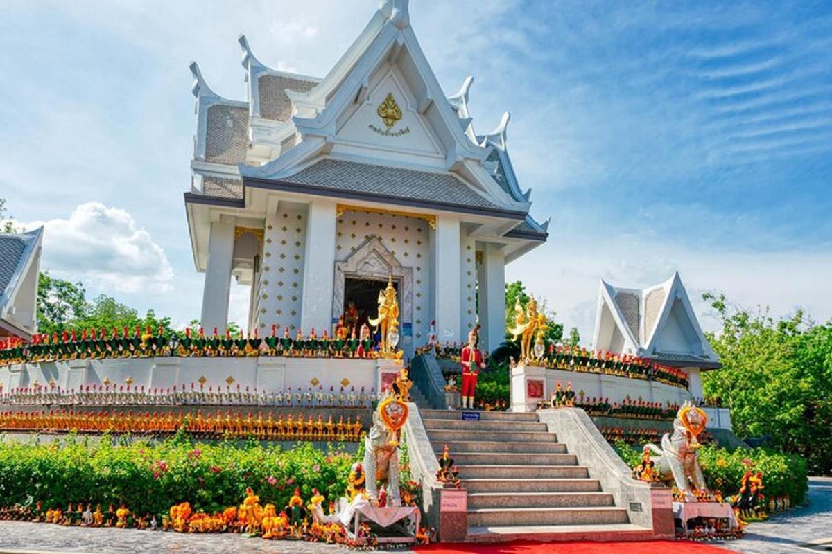 un tempio bianco con scale e fiori davanti