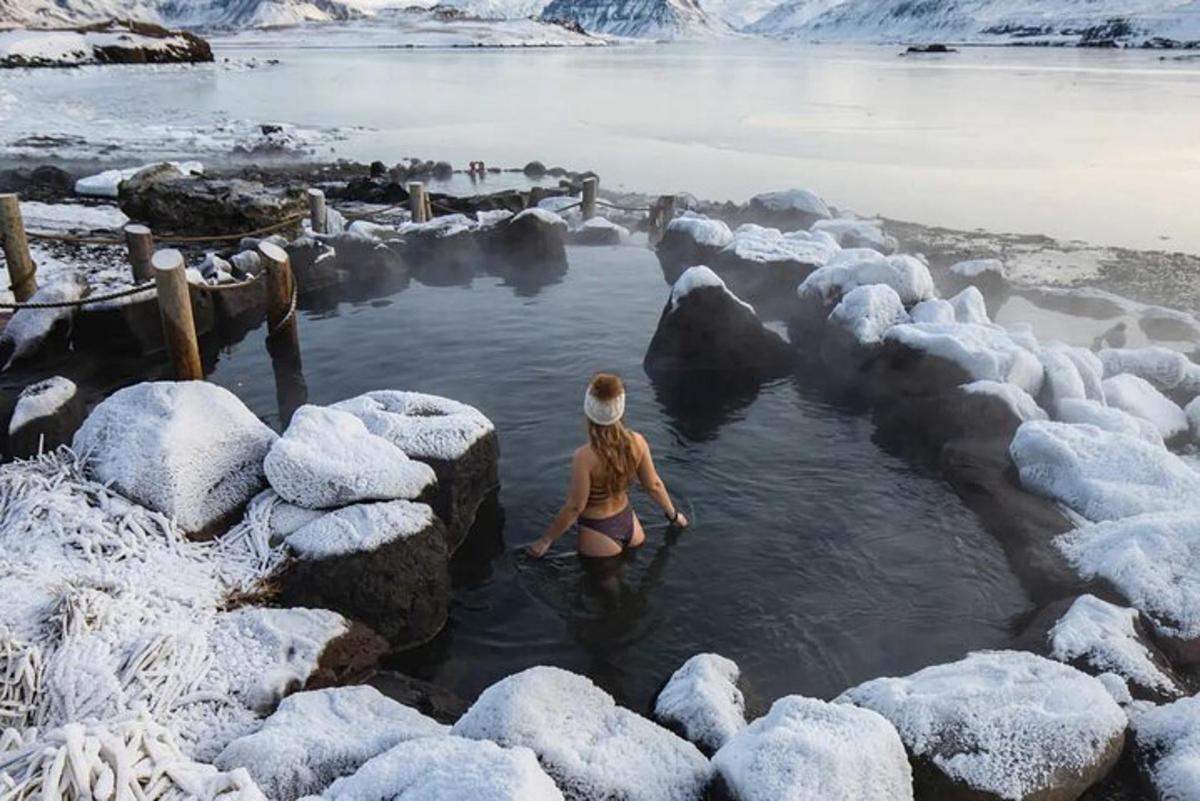 una donna in uno specchio d'acqua con rocce