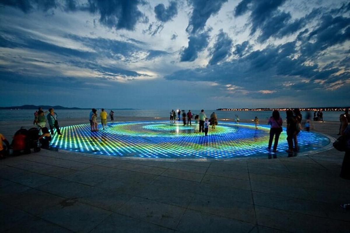 a group of people standing around a pool of lights