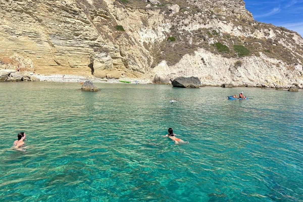 zwei Menschen schwimmen im Wasser in der Nähe eines Berges