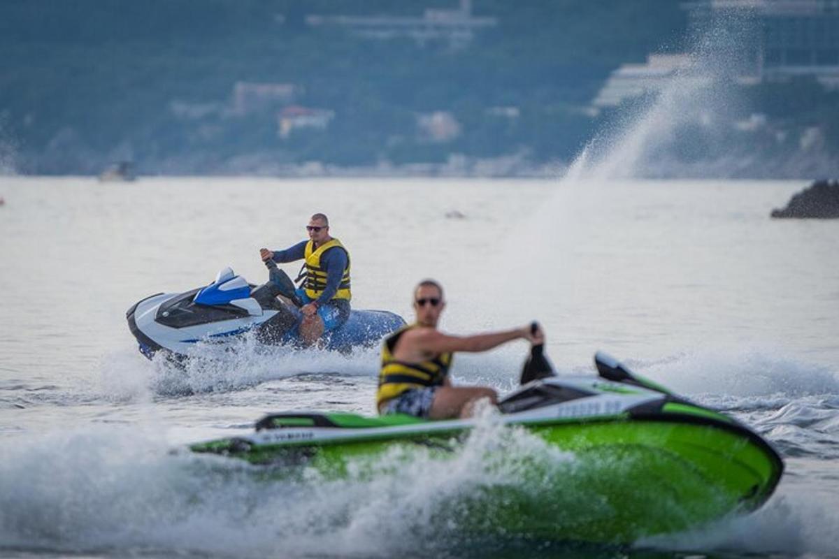 dva muži jedoucí na vodním skútru ve vodě