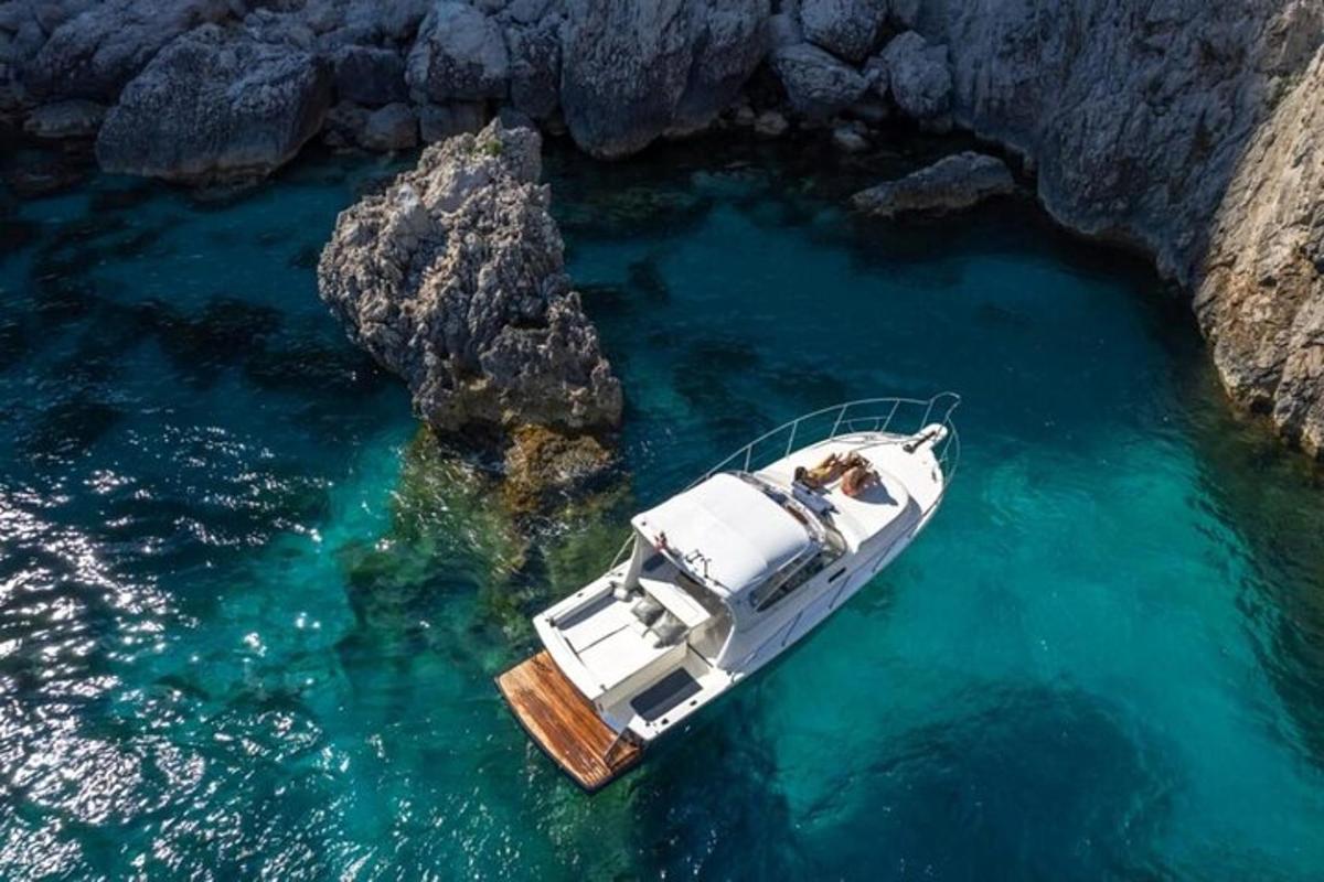 um barco na água ao lado de um penhasco