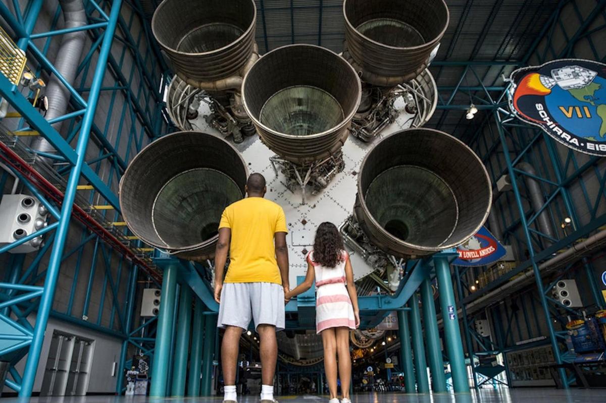 muž a žena stojící před raketou