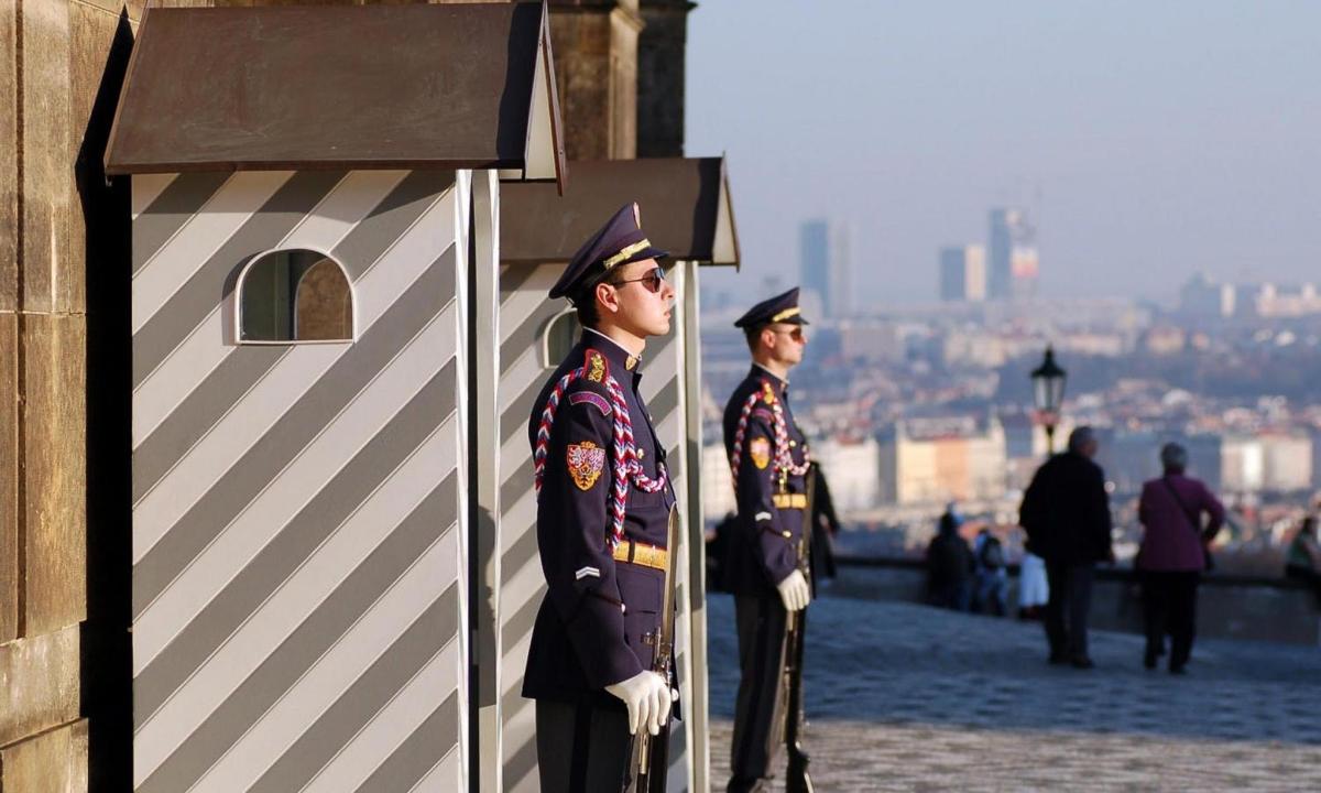 two men in uniform standing next to a building