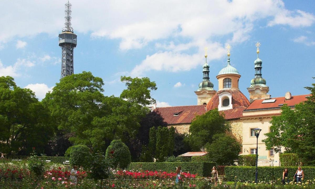 a building with a tower in the background with flowers