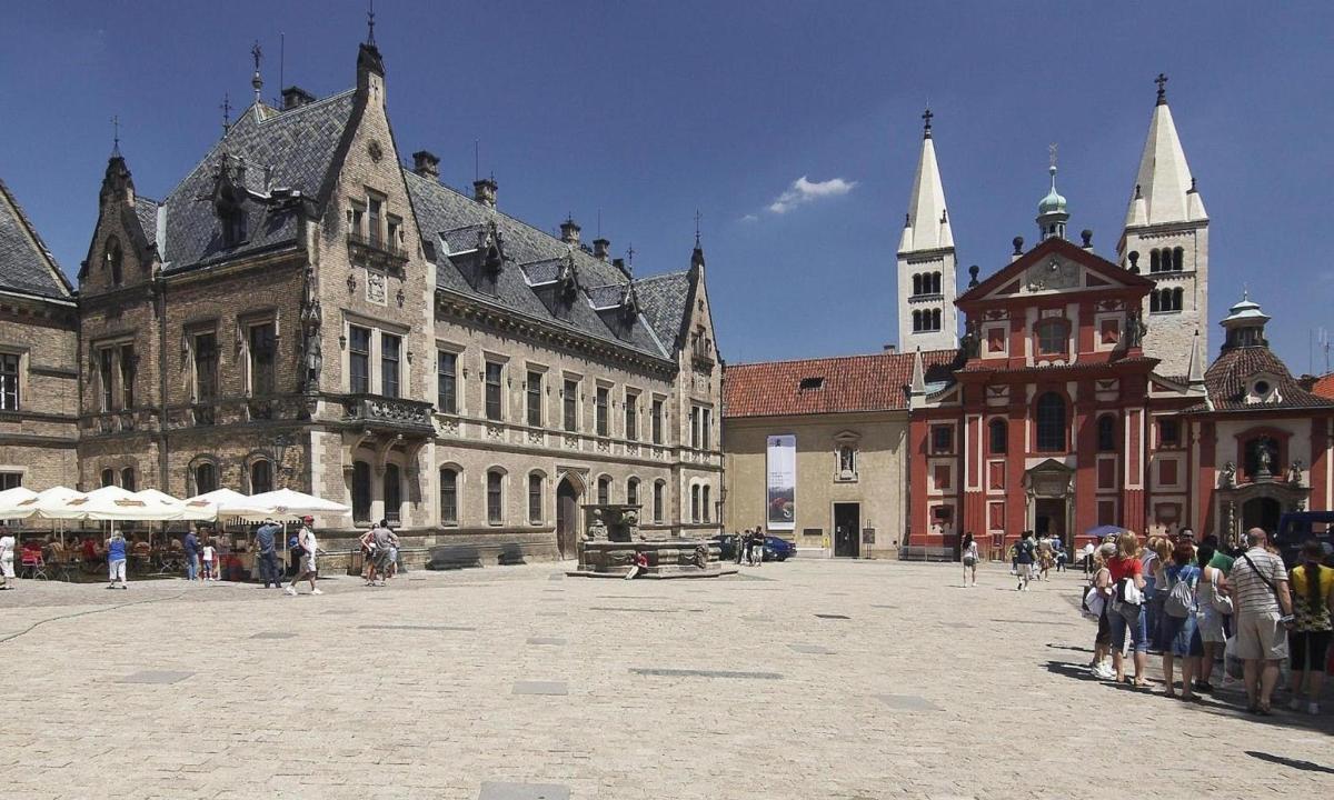 grupė žmonių, stovinčių pastato kieme