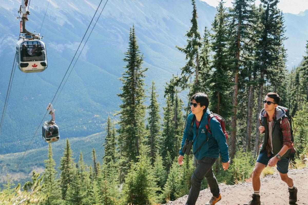 两名男子乘坐滑雪缆车在山上行走