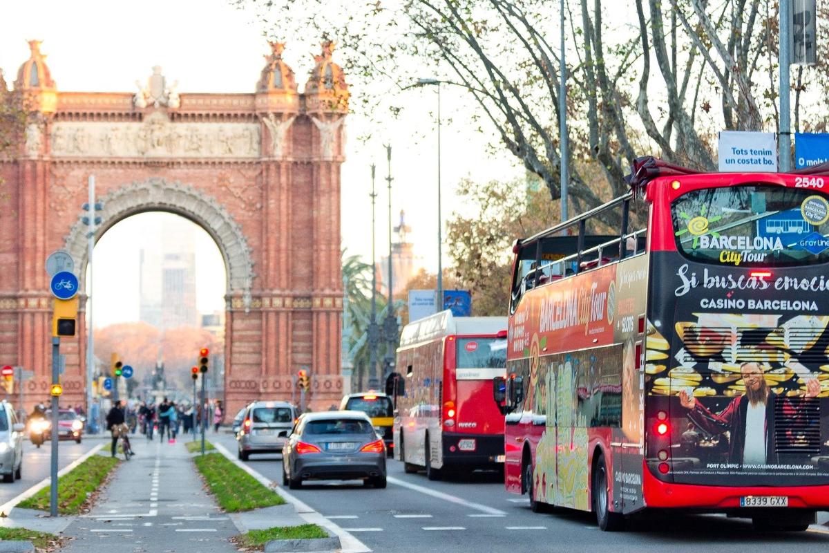 Un autobús rojo de dos pisos circulando por una calle de la ciudad.