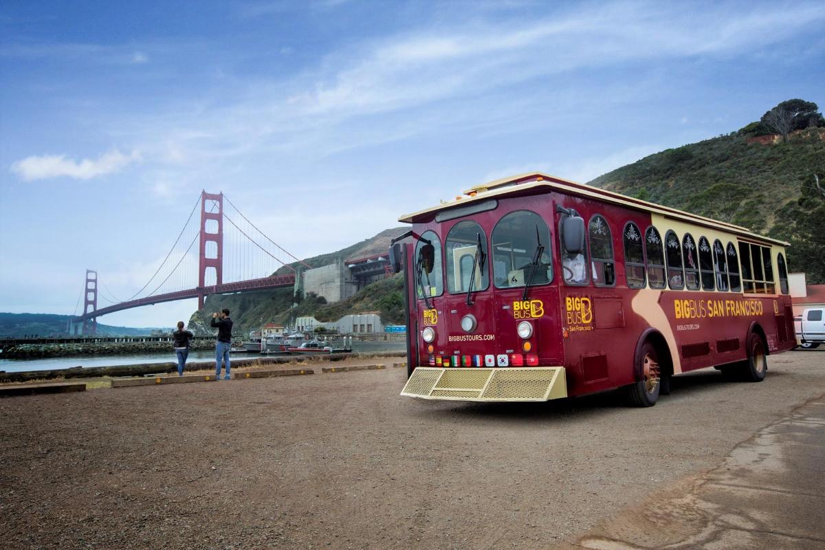 um ônibus vermelho está estacionado em frente a uma ponte