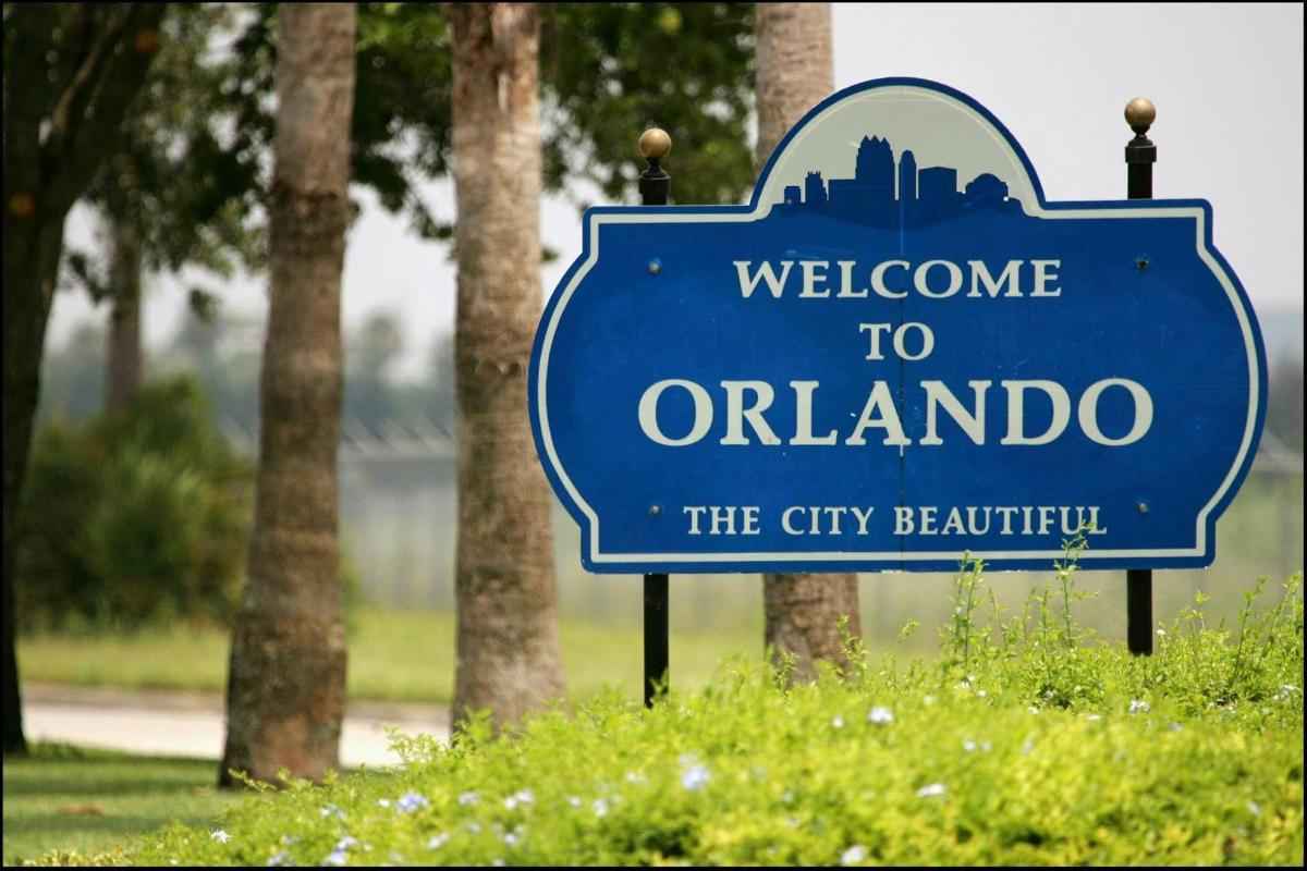 un rètol blau de benvinguda a Orlando en un parc