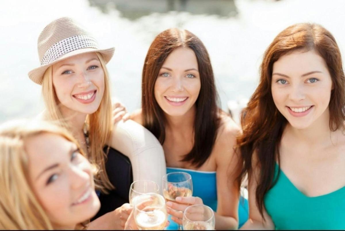 a group of women sitting at a table with wine glasses