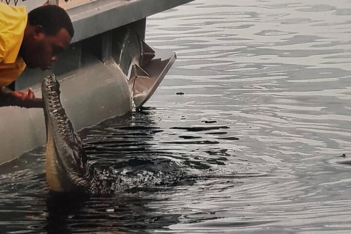 un uomo in piedi sul lato di una barca in acqua