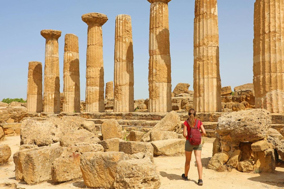 a woman standing in front of ruins