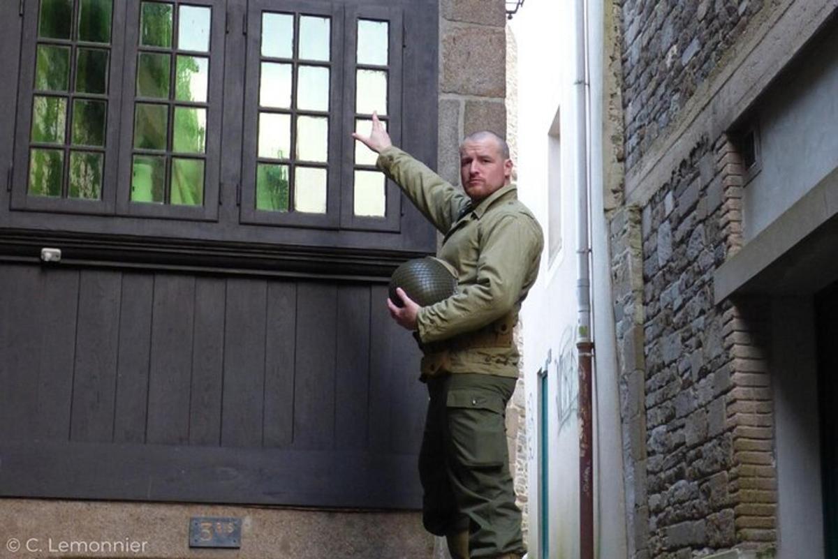 a man standing next to a building holding a ball