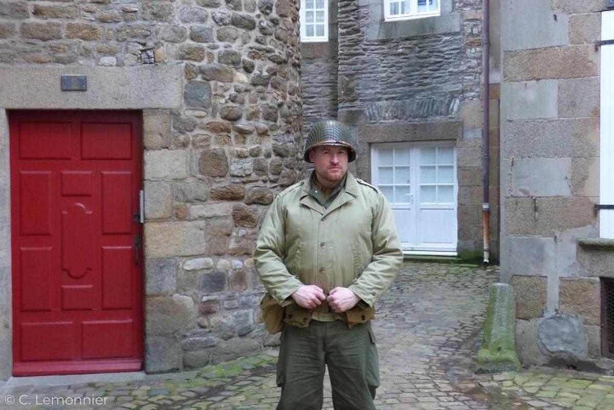 a man wearing a helmet standing in front of a building