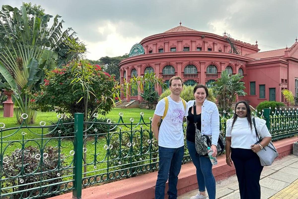a group of people standing in front of a pink building