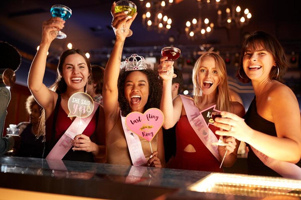 sekumpulan wanita memegang minuman mereka di sebuah bar