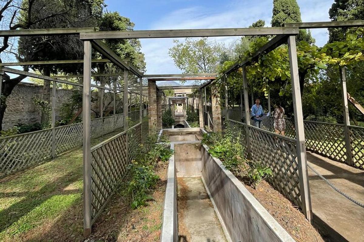 duas pessoas em pé em uma ponte sobre um jardim