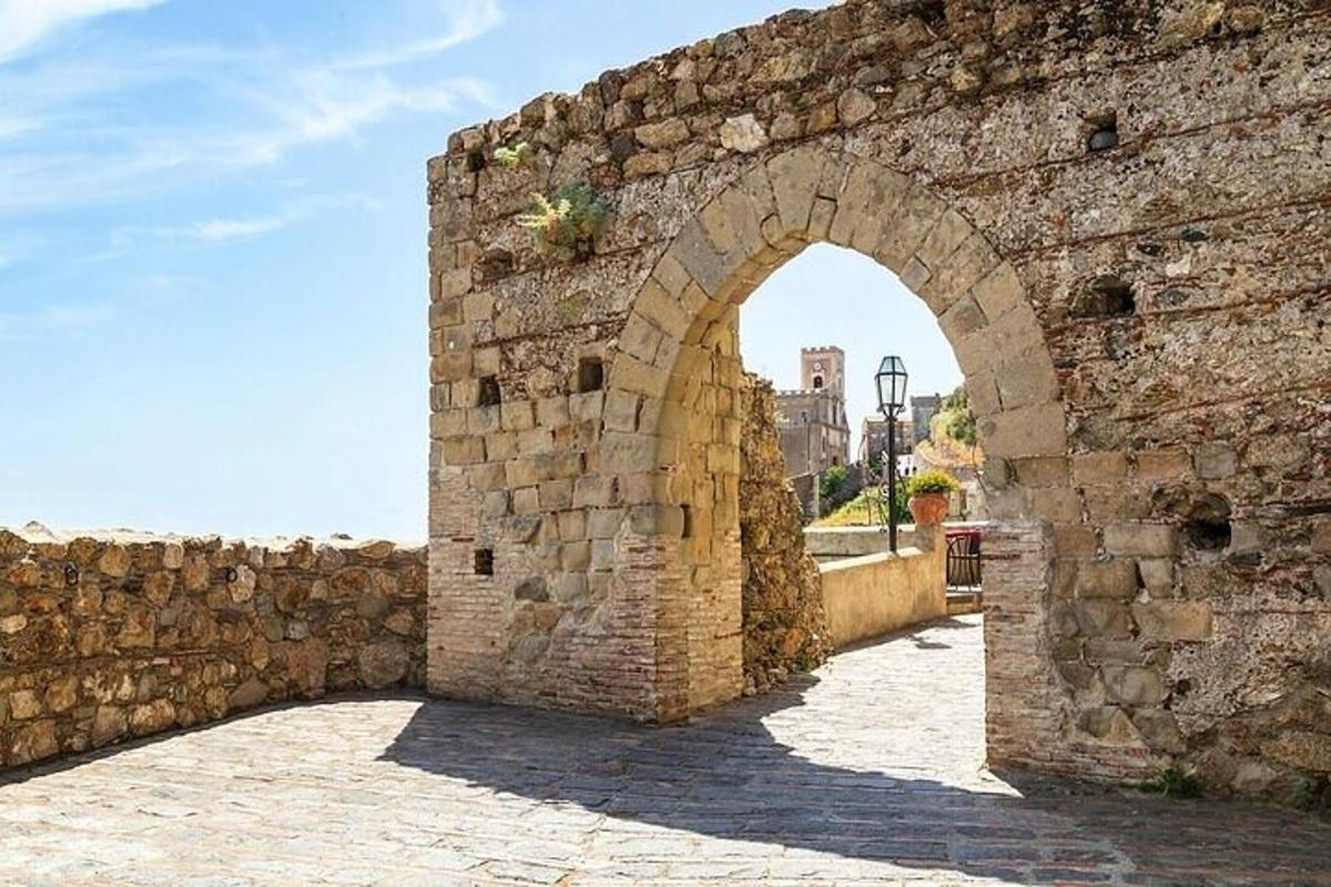 an archway in a stone wall with a street