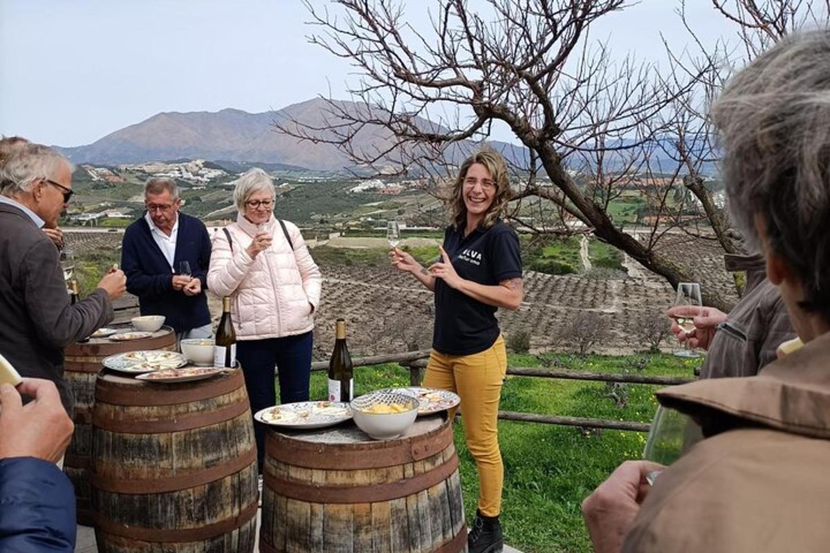 una donna in piedi davanti a un tavolo con bottiglie di vino