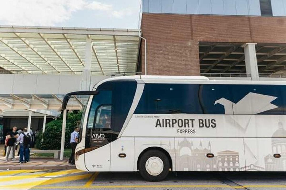 egy fehér busz parkolt egy épület előtt