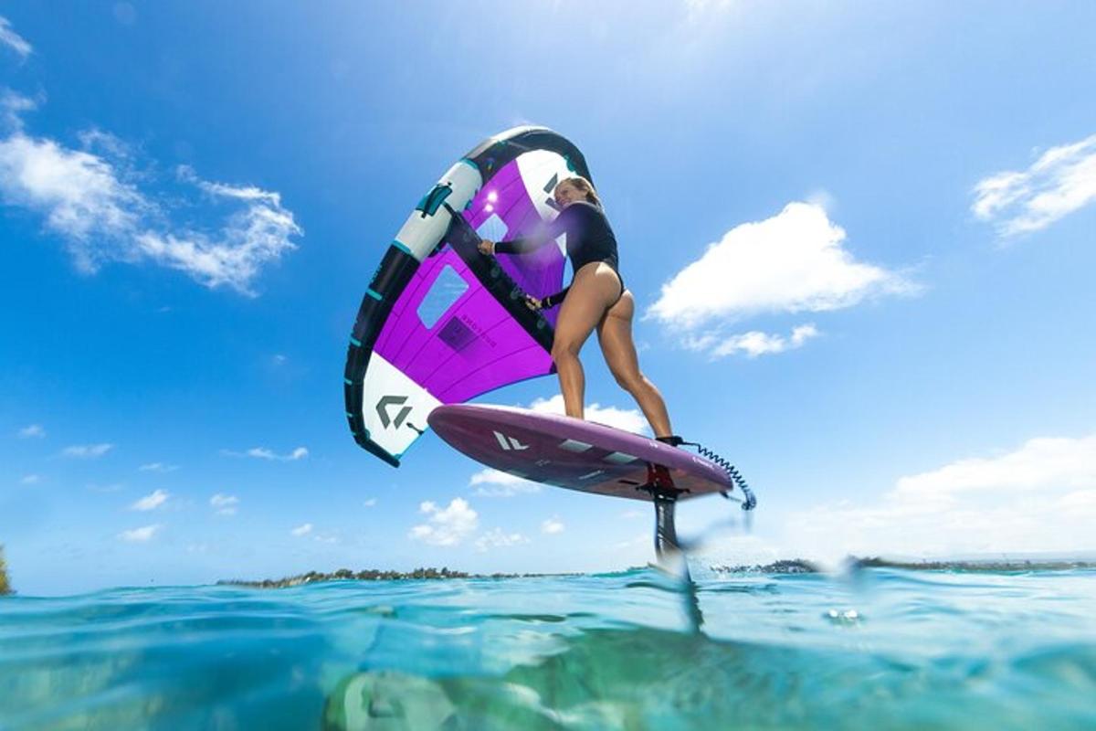 Una mujer está en una tabla de surf en el agua.