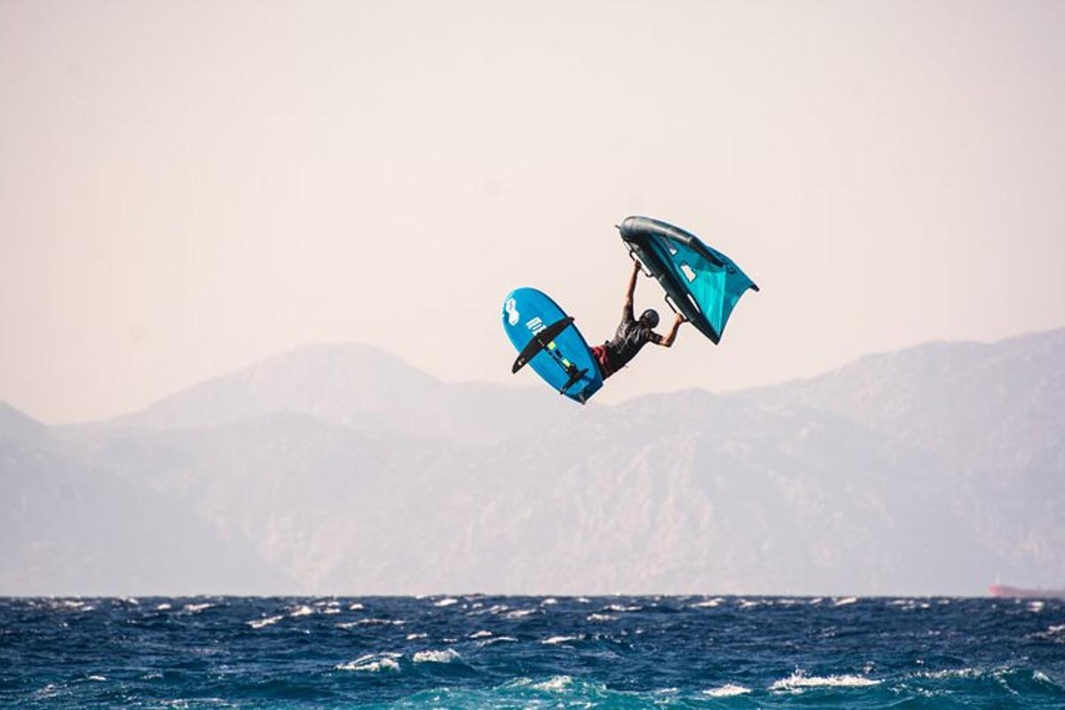 una persona volando en el aire sobre el océano