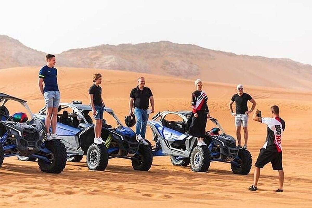 un gruppo di persone in piedi nel deserto con i quad