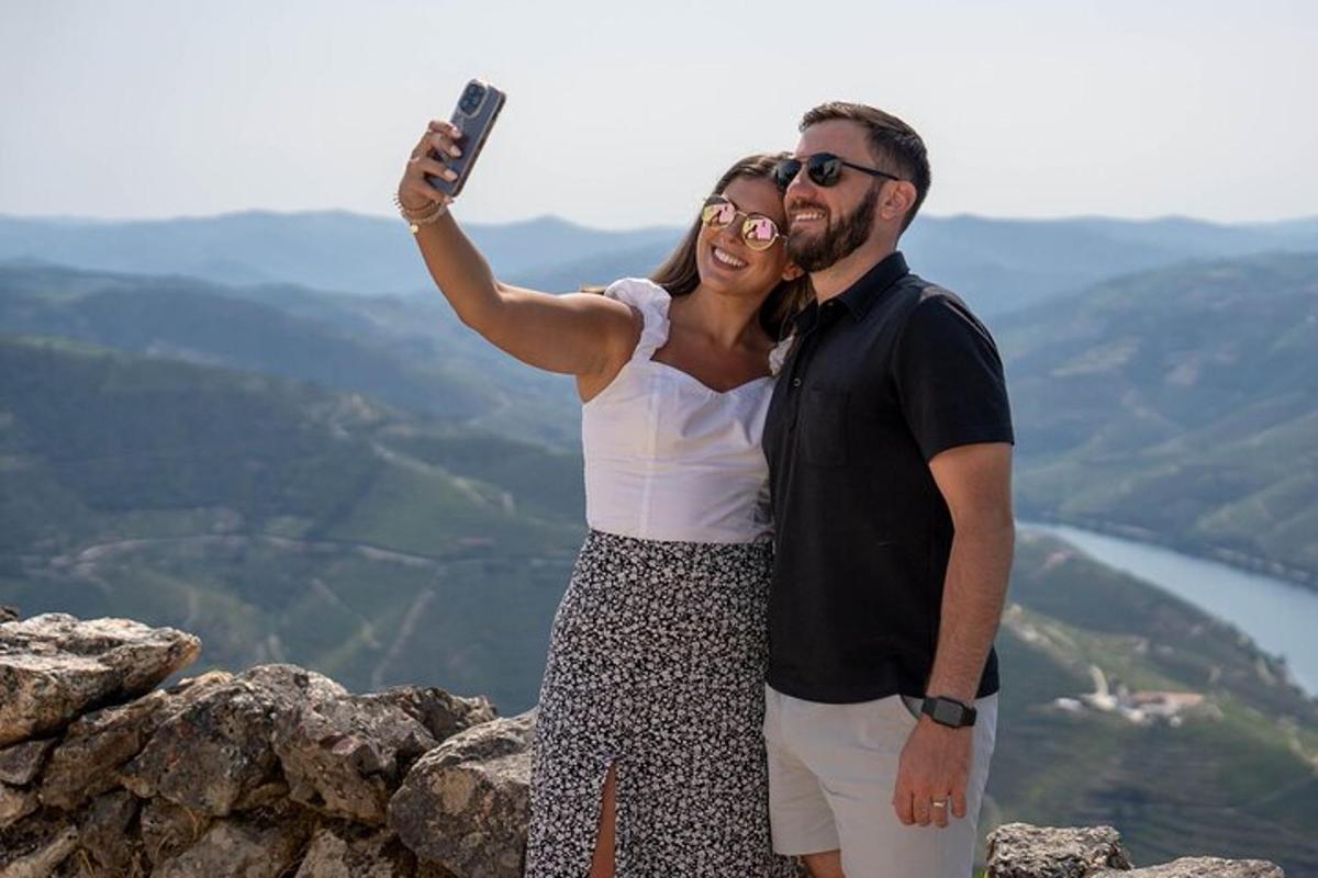 Ein Mann und eine Frau machen ein Foto auf einem Berggipfel