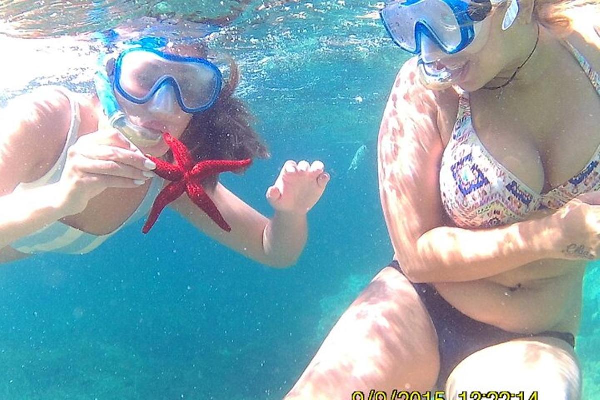 two people in the water playing with a starfish
