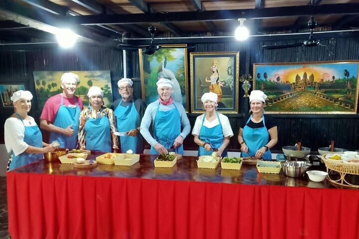 skupina lidí stojících za stolem s jídlem