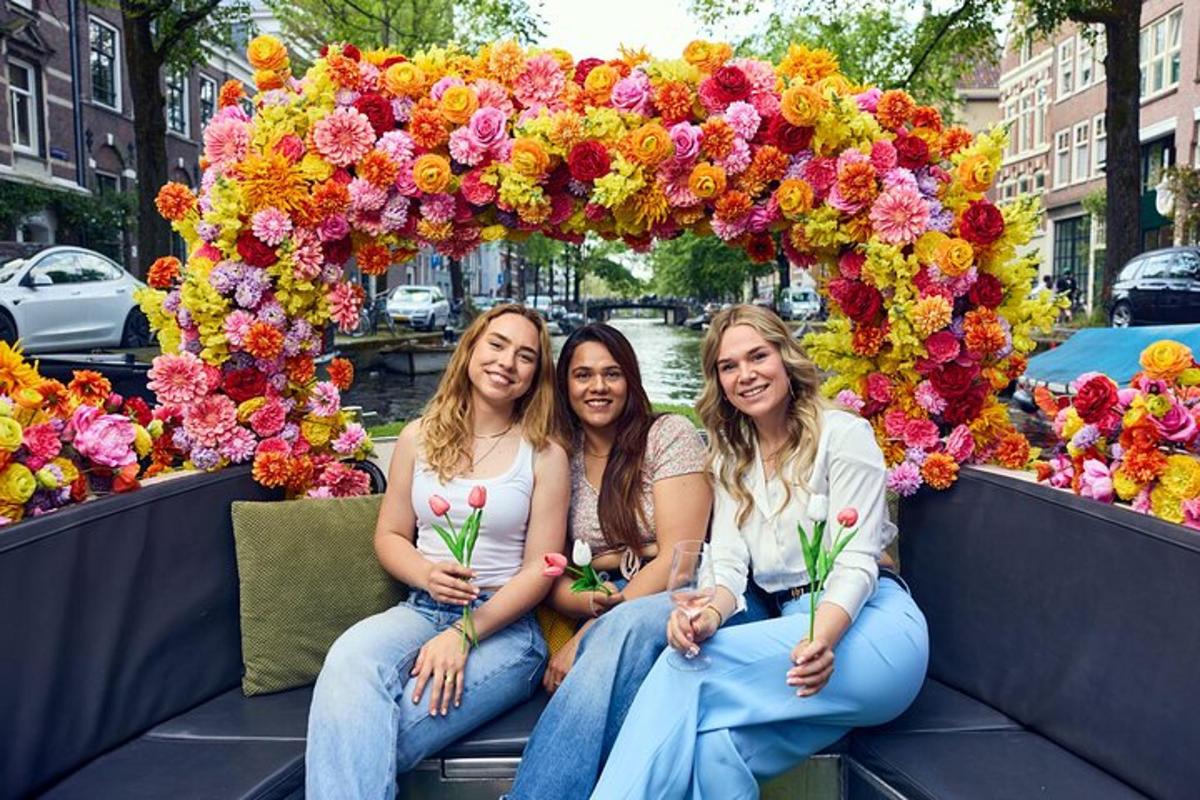 tre donne sono sedute sotto un arco floreale