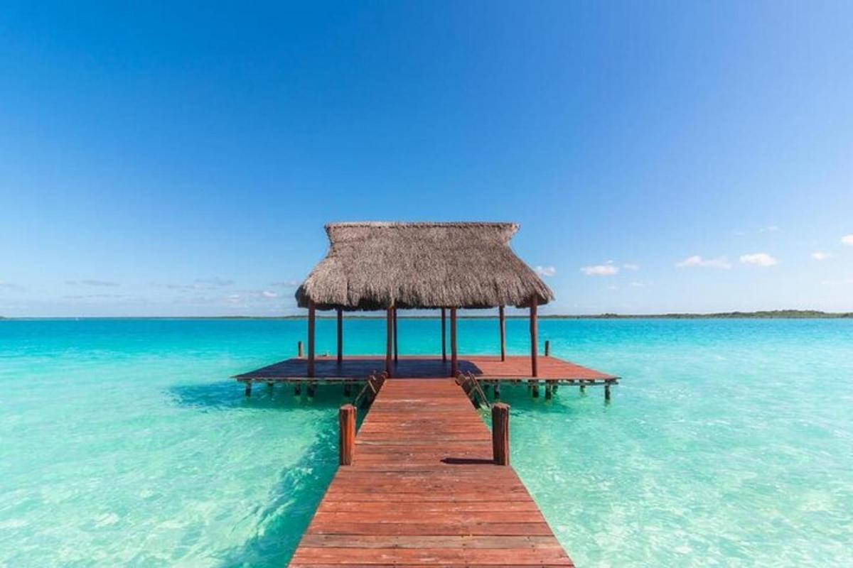 um píer no oceano com uma cabana de palha
