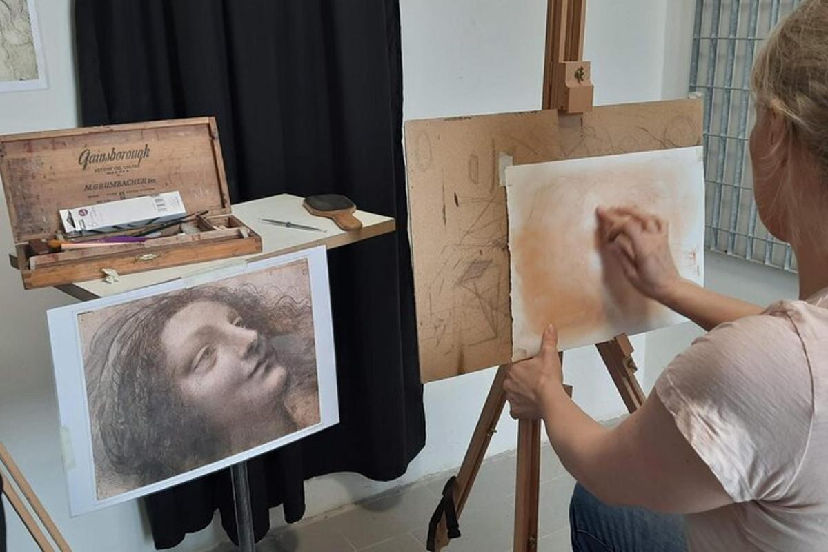 Una mujer pintando un retrato de un hombre en un caballete.