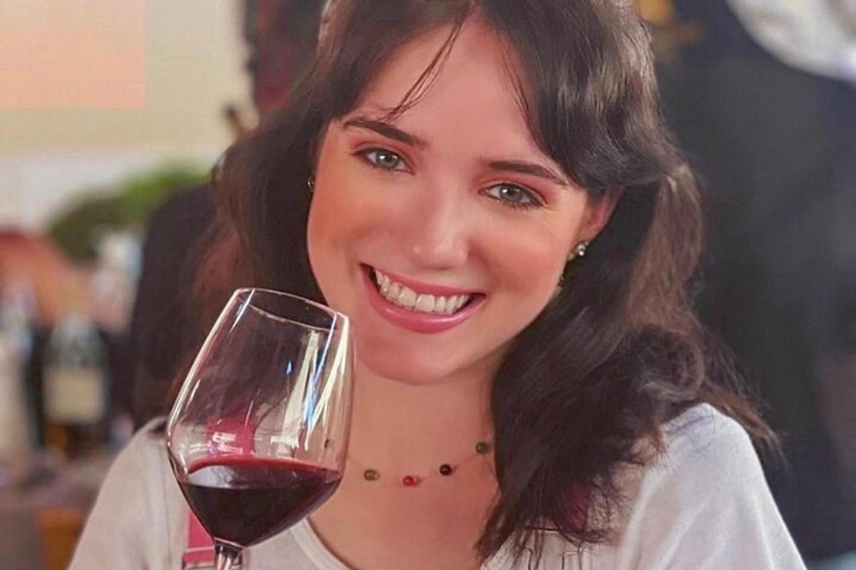 o femeie care ține un pahar de vin roșu