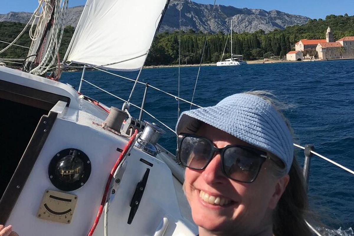 kona með hatt og sólgleraugu á báti