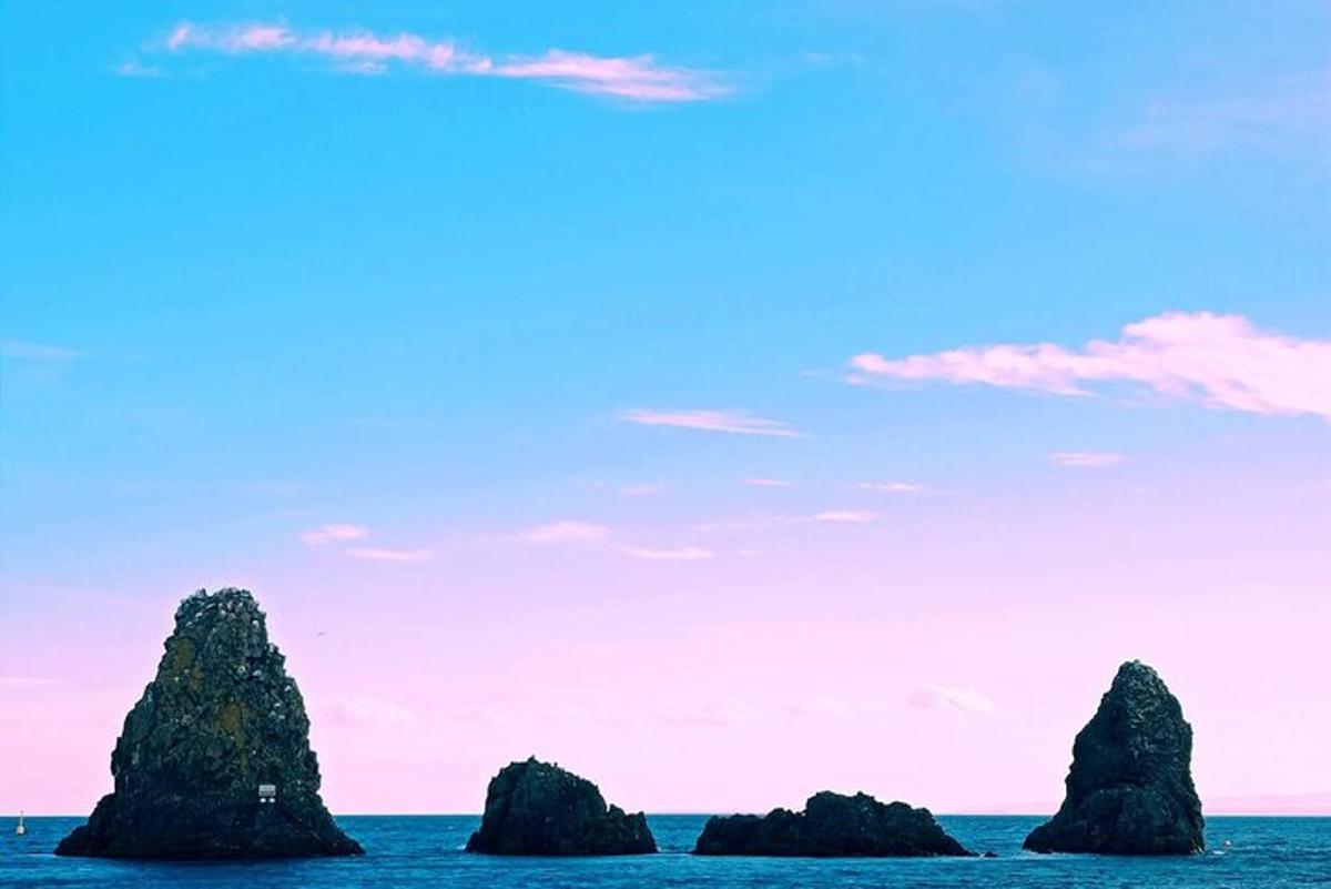un grup de roci în ocean cu un cer