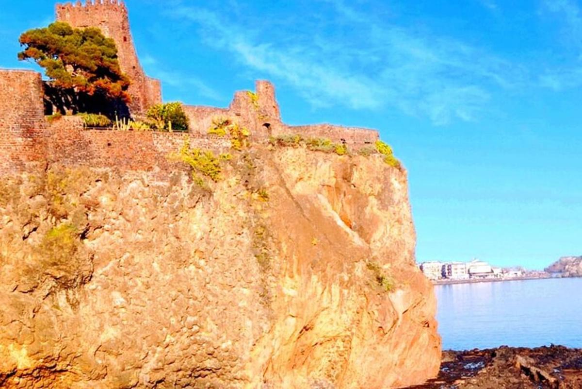 Un acantilado de roca con un castillo al lado del agua.